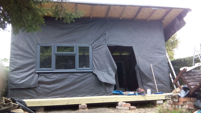Window and doors in, finally, membrane tacked on